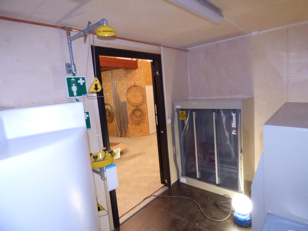 Mellanvägg och dörröppning i LCS vattenreningscontainer med nöddusch och ögonsköljare
