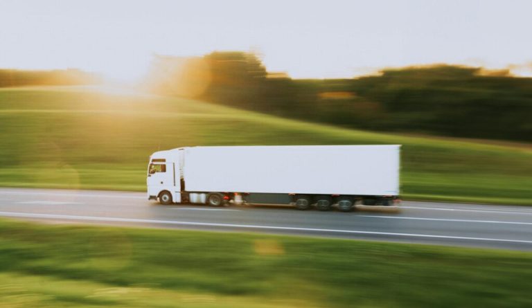 Lastbil som kör med en reefer container