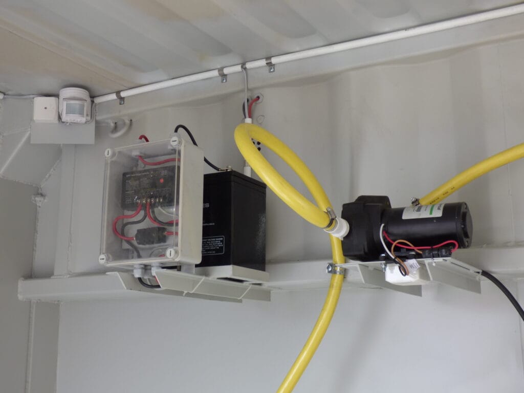 Elinstallation och pump monterad på stativ i taket på LCS asfaltscontainer