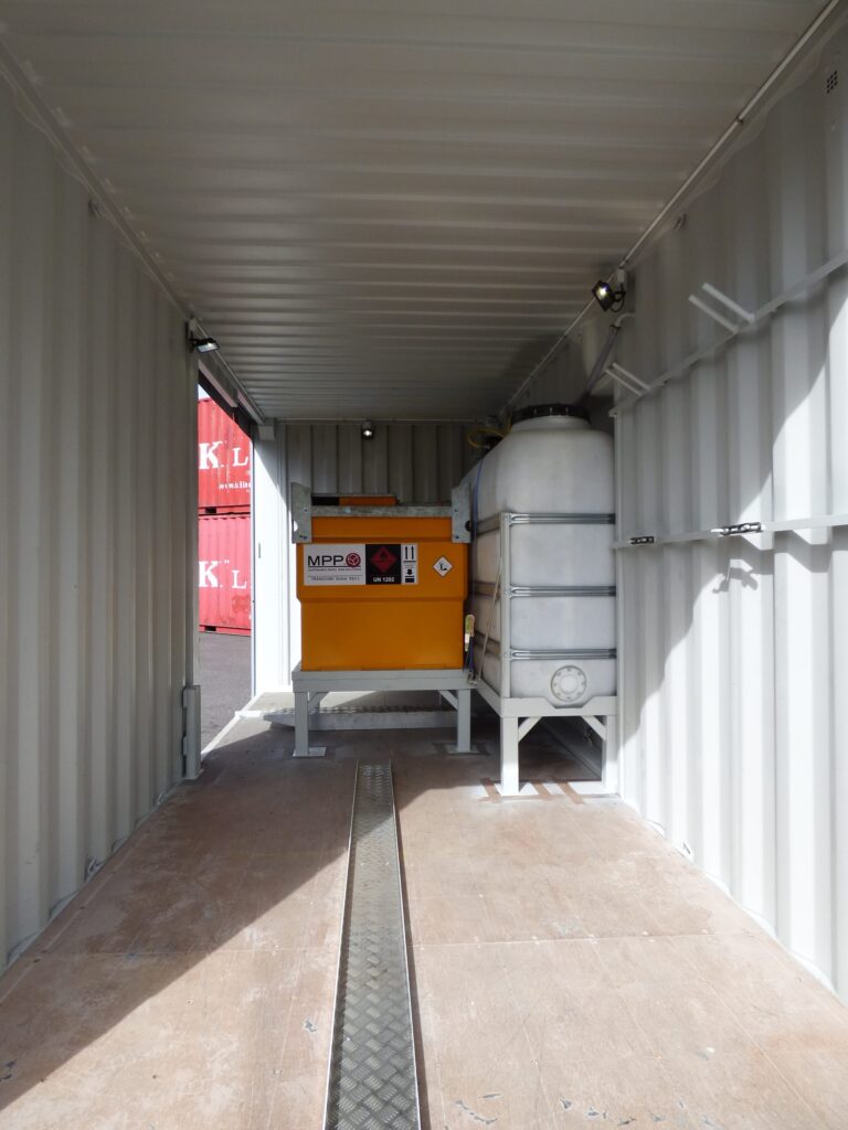 Interiör i LCS asfaltscontainer med orange tankstativ och vit tank, ramp i förgrunden