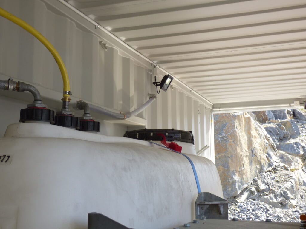 Interiör i LCS asfaltscontainer med tankinstallation, rörledningar och belysning monterad i tak