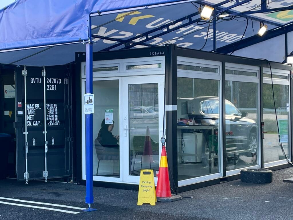 Receptionscontainer med glasade väggar och entrédörr i mobil däckverkstad byggd av LCS