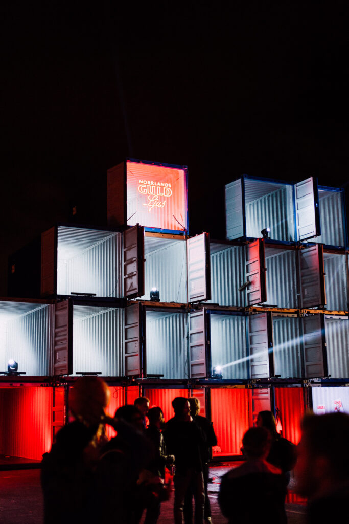 Staplade eventcontainrar som ljus- och aktivitetsyta på festival med publik i förgrunden, levererade av LCS
