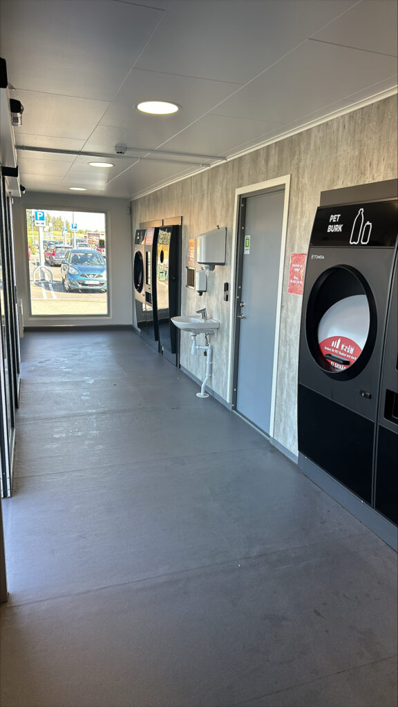 Översikt över kundyta med pantmaskiner och handfat i pantstationscontainer byggd av LCS