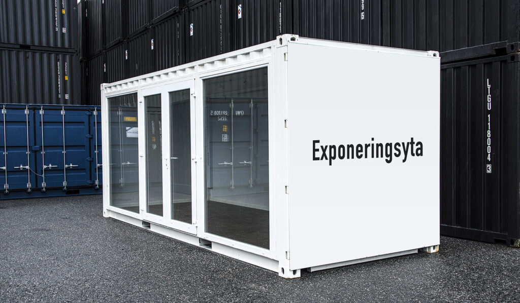 LCS specialbyggd showroom container i vitt med glaspartier fotograferad från vinkel. Exponeringsyta på kortsidan.