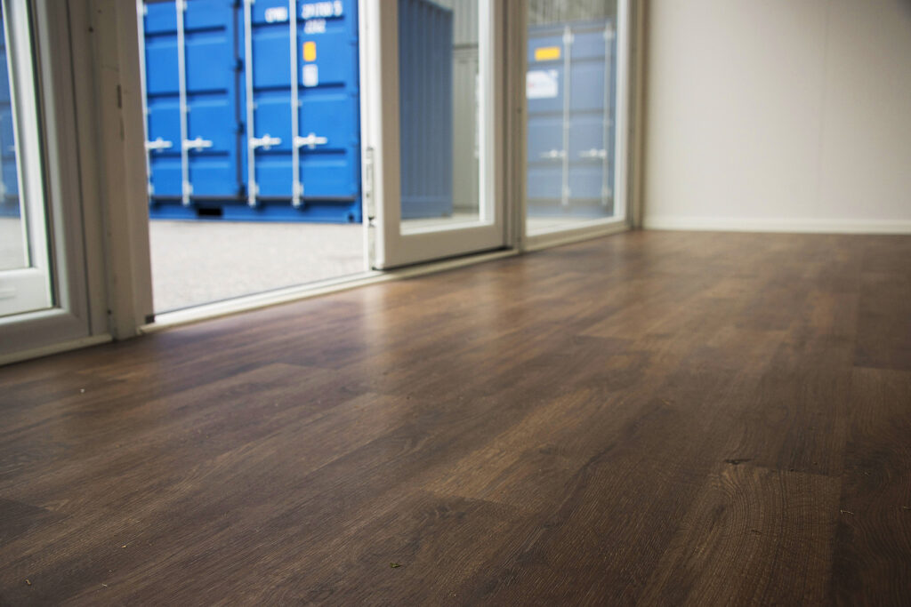 Estetiskt trägolv och öppna glasdörrar i LCS specialbyggd showroom container