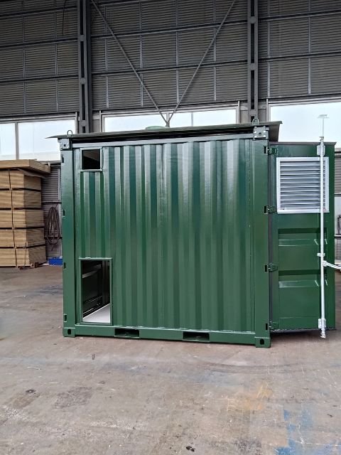 Sidovy på grön ställverkscontainer med ventilationslucka, fotograferad i LCS verkstad