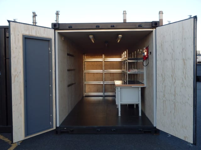Interiör i svetscontainer med hyllor, arbetsbänk och krokar för verktyg, byggd av LCS