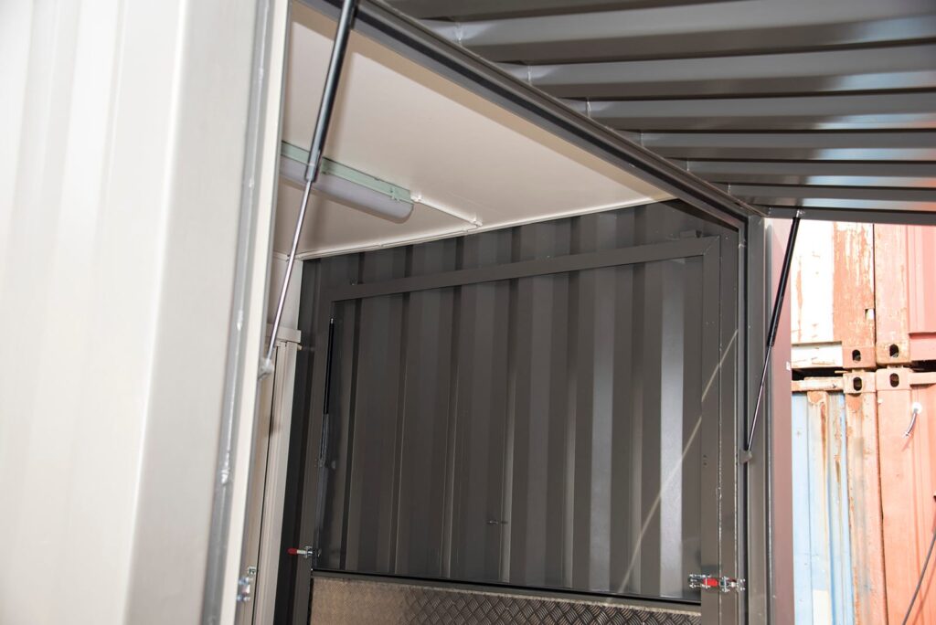 Detalj på nedfällbar sida med gasfjädrar och belysning i utbildningscontainer byggd av LCS