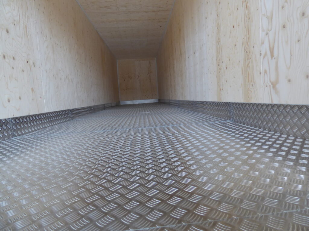 Längsgående vy av aluminiumbalja och plywoodbeklädda väggar i vattenreningscontainer byggd av LCS