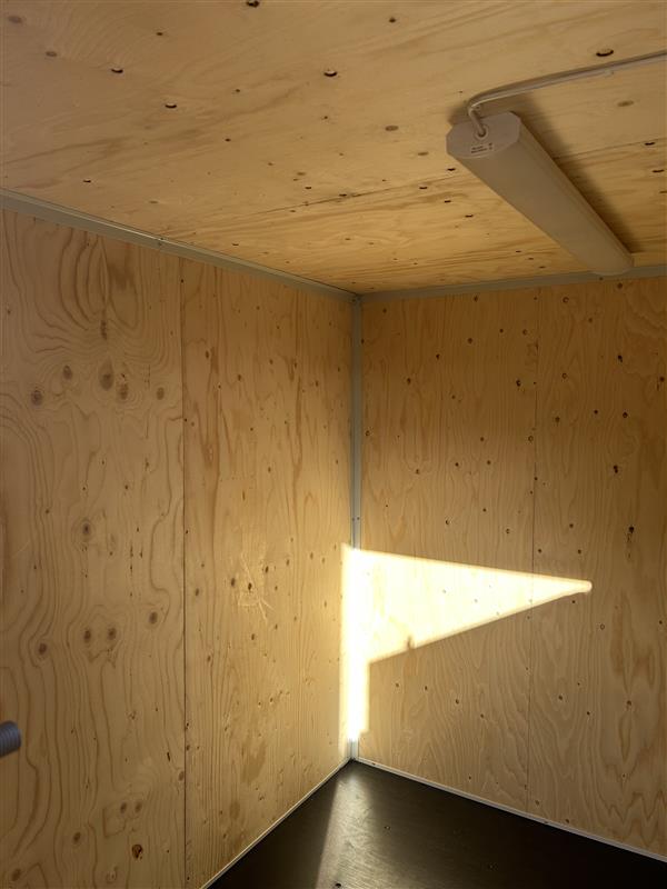 Invändig vy av 20 fot Byggcontainer Open Side Byggis med väggar och tak i plywood samt monterad belysning
